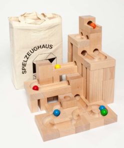 Zdjęcie: Przykładowy labirynt dla kulek w konstrukcji z drewnianych klocków ze żłobieniami tworzącymi trasę - "Kaden S - duży zestaw w torbie" - torba widoczna z tyłu za konstrukcją